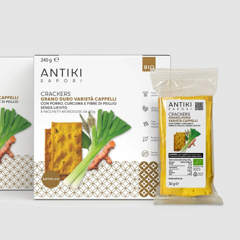 Crackers Antiki Sapori di grano Cappelli con porro e curcuma, confezione bianca e monodose trasparente.